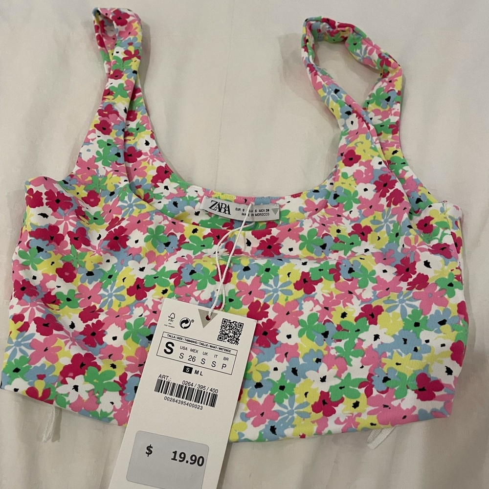 A small crop top with green, red, white, red and pink flowers. It still has tags